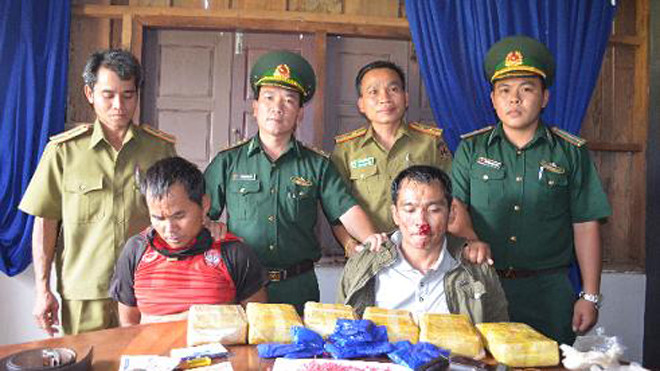 Lực lượng chức năng tạm giữ 2 đối tượng Bun Liêng, Thao Xay và tang vật. Ảnh: Bộ đội Biên phòng Quảng Trị cung cấp.