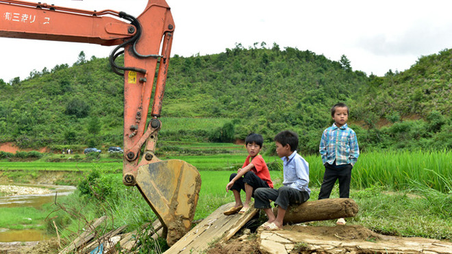 Trước ngày khởi công, nhiều trẻ em bản Páo Khắt đến xem máy xúc và công tác chuẩn bị. Ảnh: Nguyễn Long