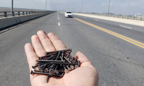 Chưa đầy 20 m có đến gần 30 cây đinh dài 5-7 cm nằm trên mặt cầu. Ảnh: Giang Chinh