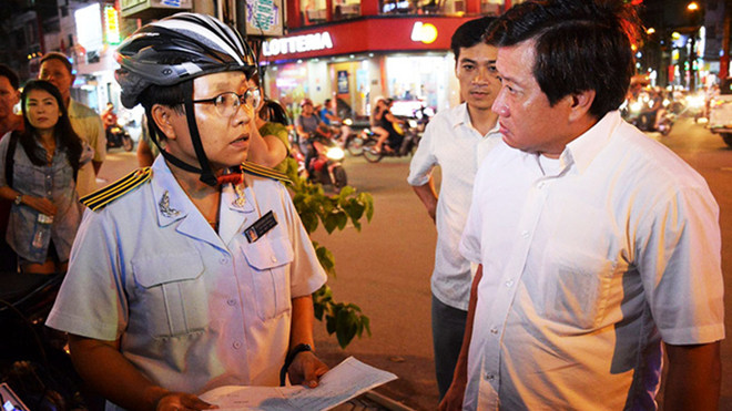 Bà Nguyễn Ngọc Liên Thảo - tổ trưởng quản lý đô thị phường Tân Định trao đổi với ông Đoàn Ngọc Hải về việc để vỉa hè bị lấn chiếm tối 4/9 