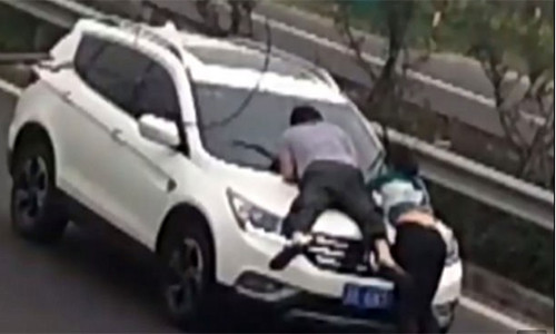 Cô gái và người yêu mới không ngại đu bám ca pô đòi tiền dù có thể nguy hiểm tới tính mạng. Ảnh cắt từ clip.