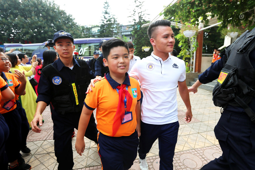 Quang Hải vui vẻ bước vào cùng các em học sinh