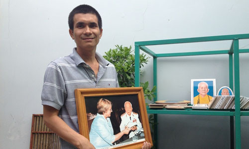 Nguyễn Văn Tứ bên cạnh bản sao tấm ảnh men màu tặng đại tướng Võ Nguyên Giáp.