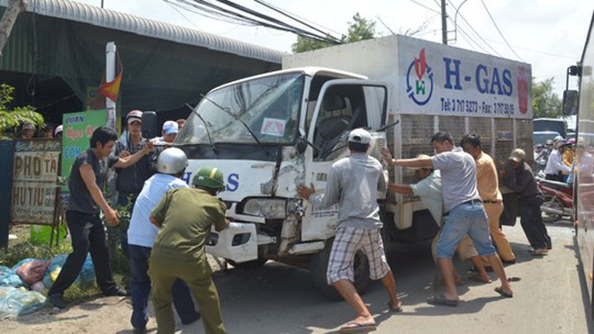 Cảnh sát giao thông cùng người dân đẩy xe tải vào lề đường