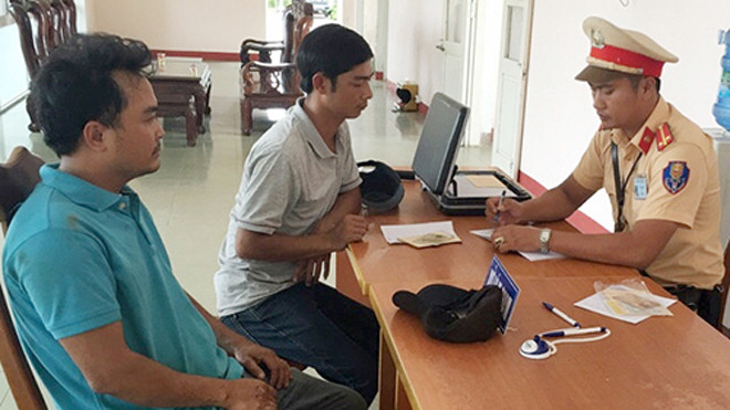 Tài xế Tưởng (bên trái) bị cảnh sát lập biên bản vi phạm. Ảnh: Sơn Thủy.