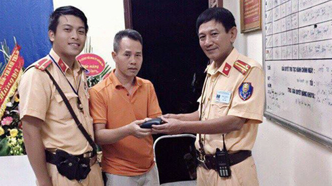 Trung tá Dũng và trung uý Linh trao trả chiếc ví cho anh Hải. 