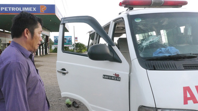 Ông Tuấn và chiếc xe cấp cứu với nhiều vết chém, đập do bị ngăn không cho vào chở bệnh nhân