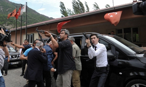 Các vệ sĩ của ông Kemal Kilicdaroglu chĩa súng về các ngọn đồi sau vụ tấn công. Ảnh: AP.