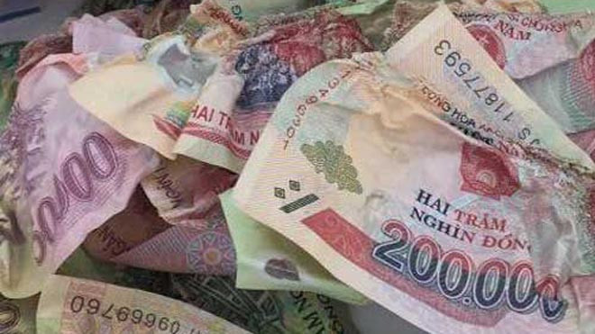 31 triệu đồng bị biến dạng, cong queo, mất mép và không thể miết phẳng trở lại: Ảnh Đình Hậu/Dân Việt