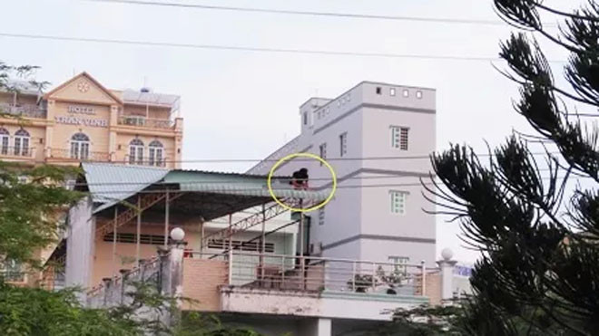 Nam thanh niên ngồi cố thủ trên nóc nhà dân ở tầng 2.