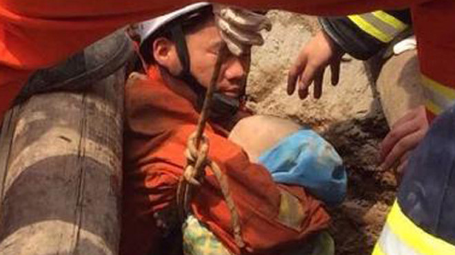 Nhân viên cứu hộ bế Lele từ dưới giếng lên. Ảnh: Sina.