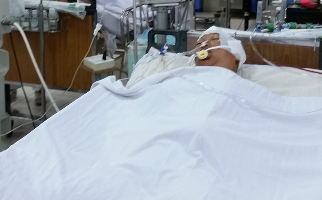 Chị Xuân sau ca mổ lấy máu tụ trong não vẫn đang hôn mê sâu. Ảnh: Quốc Ngọc