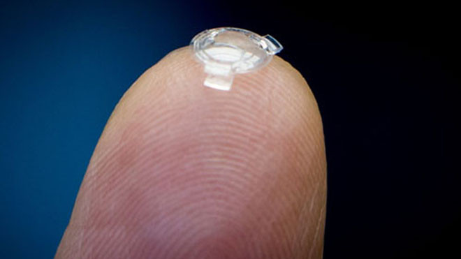 Bác sĩ Garth Webb đặt thấu kính sinh học trên ngón tay. Ảnh: Canadian Press