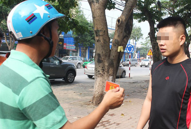 Chiến sỹ CSGT mặc thường phục xuất thẻ ngành, đọc lỗi người vi phạm.