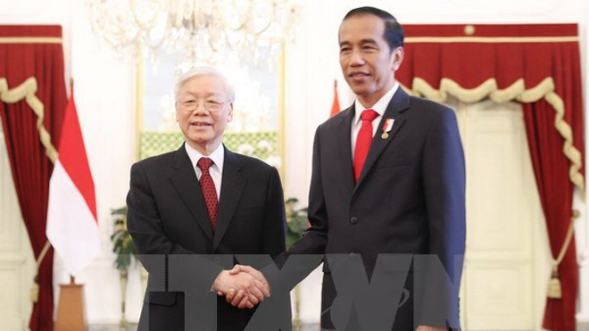Tổng thống Indonesia Joko Widodo đón Tổng Bí thư Nguyễn Phú Trọng. (Ảnh: Trí Dũng/TTXVN)