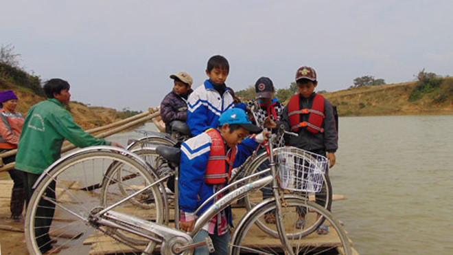 Học sinh Tiểu học luôn vất vả đưa xe lên thuyền mỗi khi qua sông. Ảnh: Đức Hùng