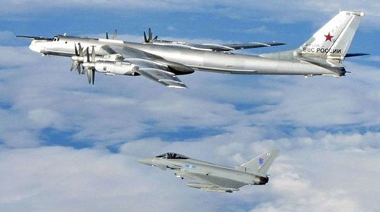 Một chiếc Tu-95 Bear (phía trên) được chiến đấu cơ Typhoon hộ tống ra khỏi không phận Anh tháng 4-2014. Ảnh: UK Mod