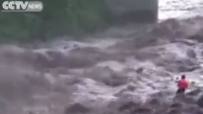 Người đàn ông đương đầu với dòng nước lũ cuồn cuộn