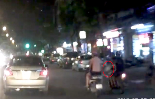 Hai thanh niên đi xe máy áp sát rồi lách sang phía bên phải giật túi xách của cô gái. Ảnh cắt từ clip