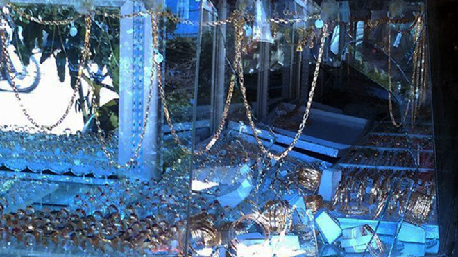 Lỗ thủng tủ kính bị tên cướp cầm đá đập vỡ, lấy vàng. Ảnh: C.A