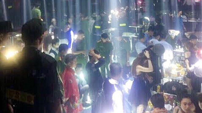 Dân chơi phải đưa tay lên đầu khi cảnh sát tìm ma túy. Ảnh: Quốc Thắng. 