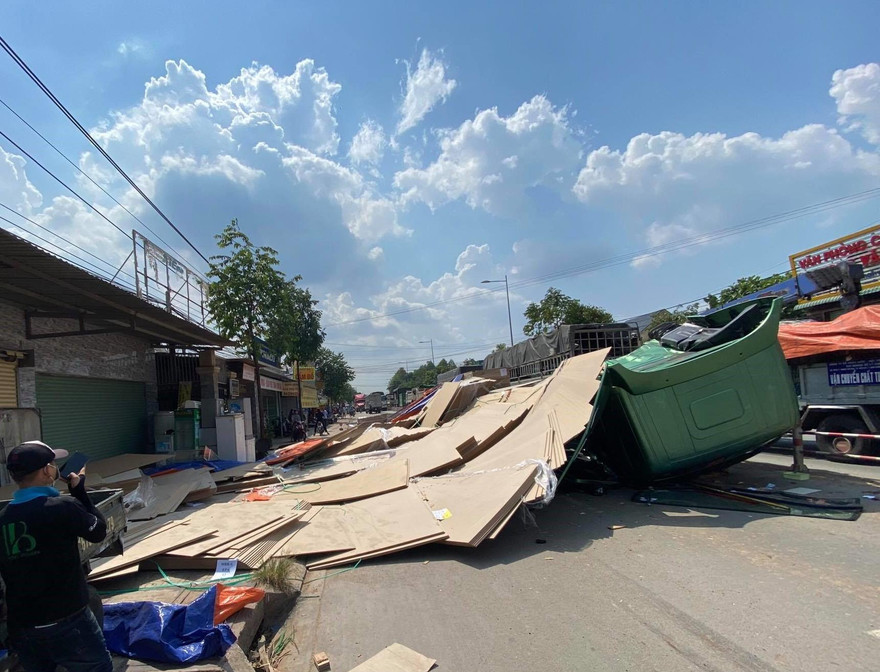 Hàng chục tấn ván ép lao xuống đường đè bẹp cabin xe đầu kéo