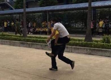 Một công nhân bị ngộ độc được đồng nghiệp cõng đi cấp cứu - Ảnh: Hoàng Long