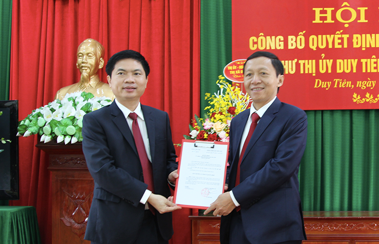 Chủ tịch UBND tỉnh Hà Nam Trương Quốc Huy (trái) trao quyết định cho tân Bí thư Thị uỷ Duy Tiên - Ảnh: Hoàng Long