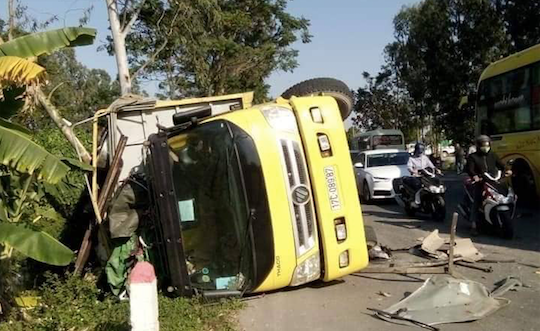 Vụ va chạm khiến xe tải bị lật nghiêng trên đường - Ảnh: Hoàng Long