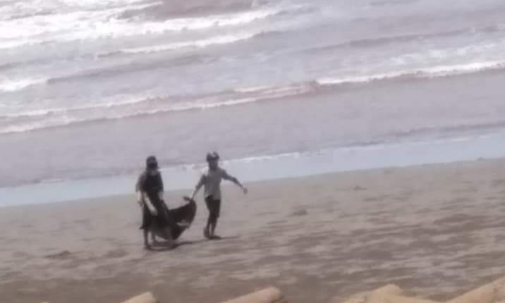 Người dân ven biển Hải Hoà phát hiện và đưa thi thể vào bờ - Ảnh: MĐ