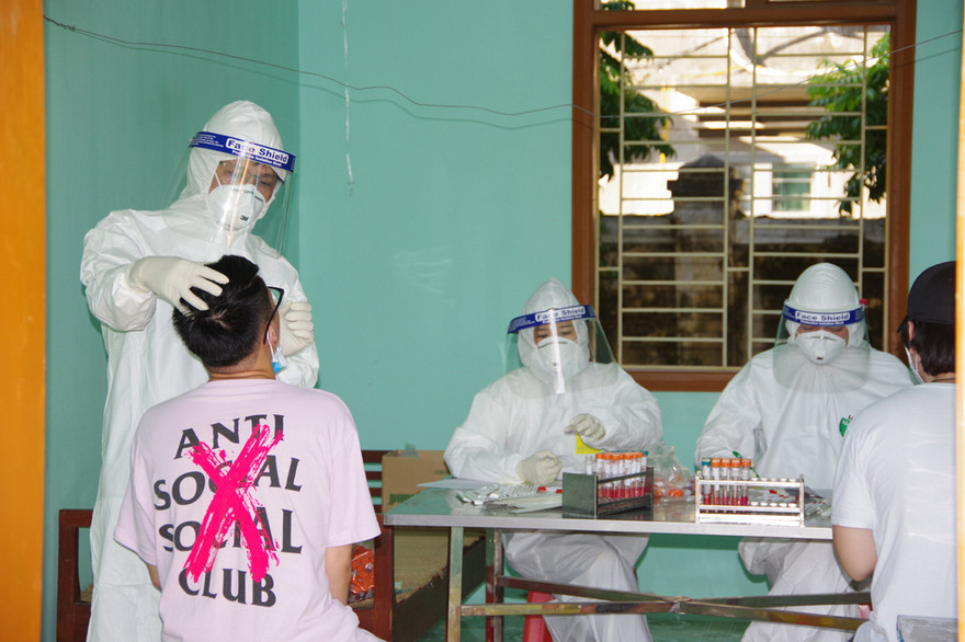 Các công dân tự nước ngoài về được khám, xét nghiệm khi đến các ly tập trung ở Trung đoàn 885 tại tỉnh Ninh Bình - Ảnh: Hoàng Long