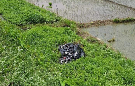 Xe máy bị tàu đâm bắn xuống ruộng cách đường tàu hàng chục mét - Ảnh: Hoàng Long