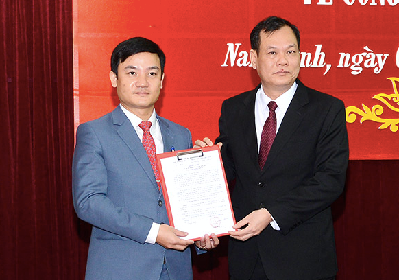 Phó Bí thư Thường trực Tỉnh uỷ Nam Định (phải) trao quyết định và chúc mừng tân Chánh Văn phòng Tỉnh uỷ - Ảnh: Hoàng Long