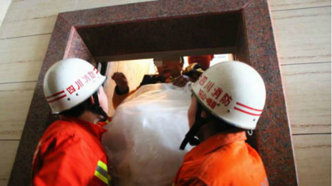 Cô dâu được lực lượng cứu hỏa đỡ xuống khỏi thang máy bị kẹt. Ảnh: CEN.