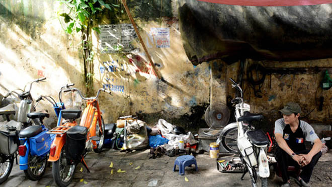 Những chiếc moped cổ của Pháp tại một hiệu sửa xe đơn sơ nhưng tồn tại từ hơn 20 năm nay trên vỉa hè một ngõ nhỏ tại Vân Hồ, Hà Nội. Ảnh: Xavier Bourgois. 