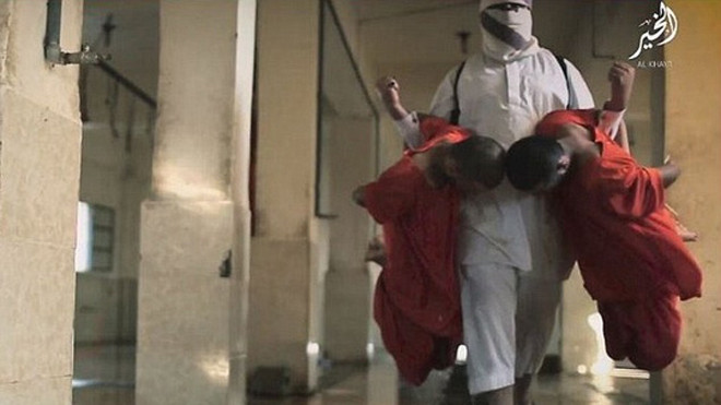 Tên đao phủ trong trang phục màu trắng, tay xách hai tù nhân đưa vào lò mổ. Ảnh: Daily Mail