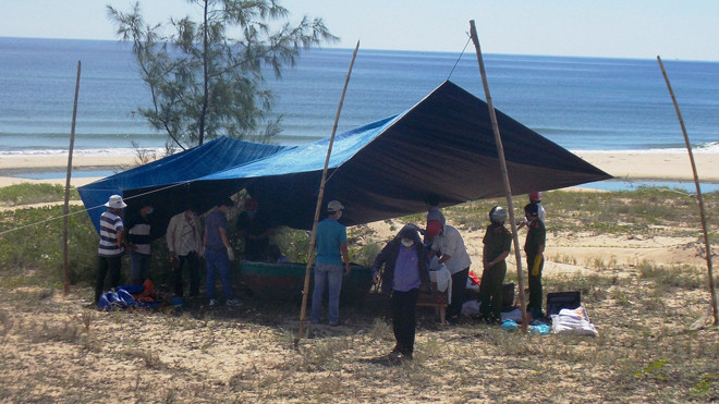 Lực lượng chức năng đang khám nghiệm thi thể 