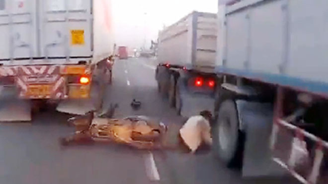Thoát chết trong gang tấc khi luồn lách qua 2 xe tải
