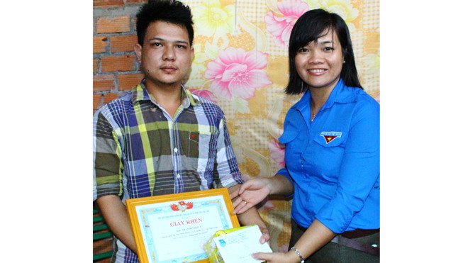 Chị Nguyễn Huỳnh Thu (bên phải) tặng giấy khen cho anh duy