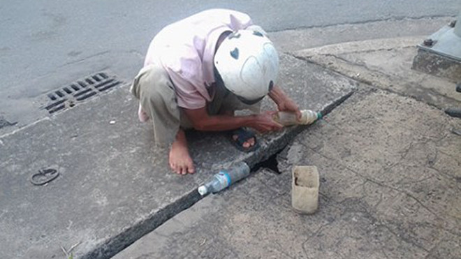 "Thợ câu” Nguyễn Quốc Minh đang “tác nghiệp” qua khe hở của miệng ống cống thoát nước trên đường Cách Mạng Tháng Tám (phường Quyết Thắng, TP.Biên Hòa, Đồng Nai).
