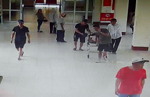 Nhóm người đàn ông đưa thai phụ bị tai nạn giao thông vào làm thủ tục nhập viện. Ảnh: Trích xuất camera