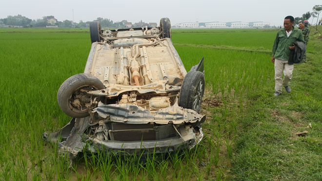 Chiếc ô tô lật ngược nằm giữa ruộng lúa