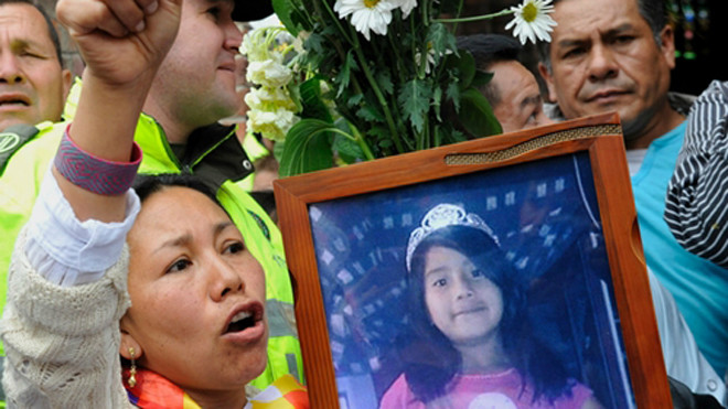 Người thương tiếc cầm di ảnh bé Yuliana trong lễ tiễn đưa. Ảnh: AFP