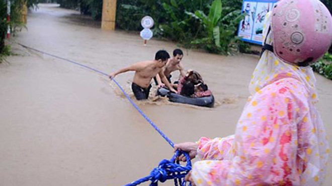 Các thanh niên địa phương hỗ trợ đưa cô và trò Trường Mẫu giáo An Hiệp (thôn Mỹ Phú 2) ra khỏi nơi bị ngập.