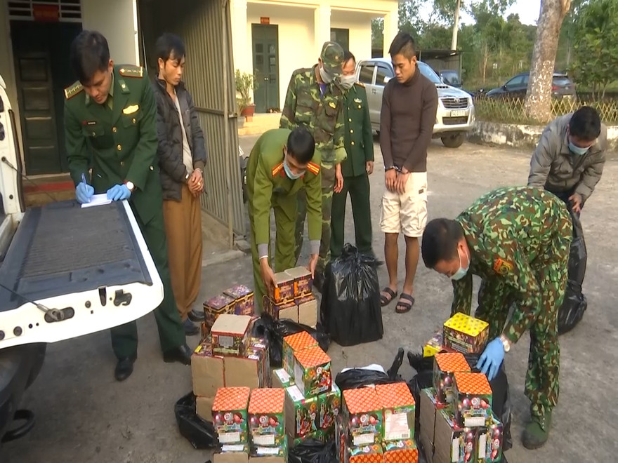 Hai đối tượng Phan Văn Thành (áo khoác màu đen) và Lê Huỳnh Đức (áo màu xám) cùng số pháo bị bắt giữ. Ảnh: M.HÙNG.