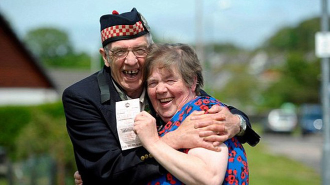 Vợ chồng ông Geordie Rhodick hạnh phúc với tờ vé số trúng giải. Ảnh: HEMEDIA