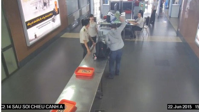 Ông Khôi vung tay ném mạnh lọ cà mắm xuống nền khu vực làm thủ tục soi chiếu an ninh sân bay - Ảnh cắt từ clip