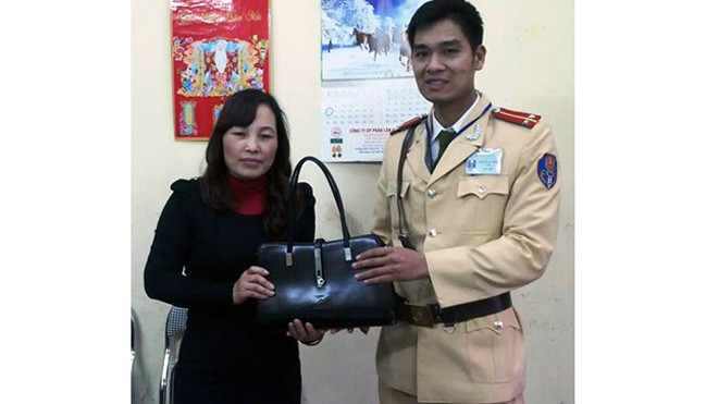 Trung úy Thành trao trả chiếc túi có nhiều tài sản giá trị cho chị Huyền.