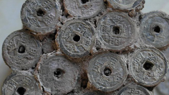 Khối tiền cổ lẫn trong đống cát.