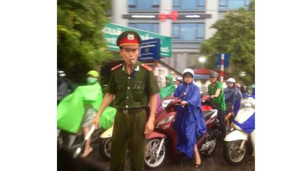Ảnh đại úy Bốn ướt sũng phân luồng giao thông dưới cơn mưa tầm tã vào chiều 23/6.